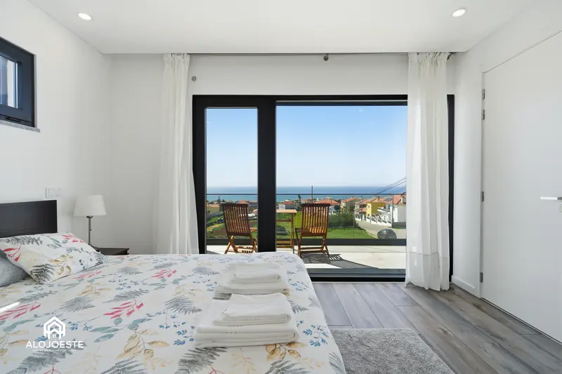 Quarto preparado para receber hóspedes, com toalhas dobradas sobre a cama